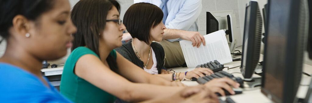 Group of women sitting at computers participating in a training program paid for with WIOA grants.